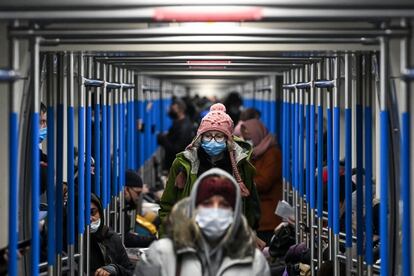 Pasajeros protegidos con mascarillas viajan en el metro de Moscú (Rusia).