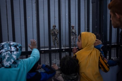 Palestinians look at Egyptian soldiers through a border fence on January 14.