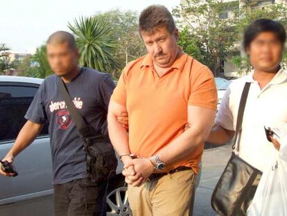 Victor Bout, esposado por dos agentes tailandeses