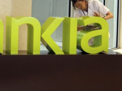 Una operaria limpia el logo de Bankia en la sede central de Bancaja. EFE/Archivo