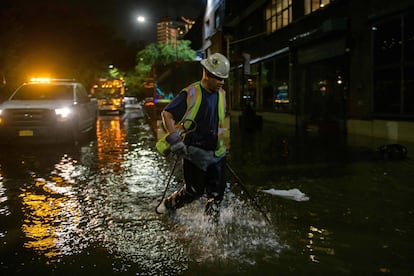 Un trabajador desbloquea los desagües en una calle afectada por las inundaciones en Brooklyn, Nueva York, a principios del 2 de septiembre de 2021, cuando las inundaciones repentinas y las lluvias récord traídas por los restos de la tormenta Ida barrieron el área.