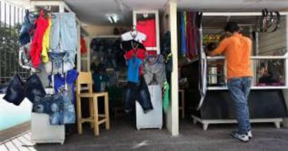 Un hombre observa mercancías en una tienda de ropa y accesorios importados ofertados por comerciantes privados este 11 de octubre de 2013, en La Habana (Cuba).