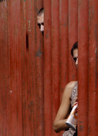 Un hombre y una mujer se asoman por una de las vallas que protegen los encierros.