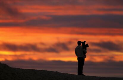 Hombres protectores, cariñosos, trabajadores...Todos ellos con un vínculo en común, sus hijos. En la imagen, un niño contempla la puesta de sol junto a su padre en Encinitas (California), el 19 de enero de 2016.