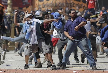 Manifestantes lançam pedras contra a polícia.