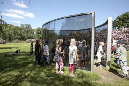 Escultura de Dan Graham <i>(Two Different Anamorphic Surfaces,</i> 2000) con la casa principal del museo Wanas al fondo.