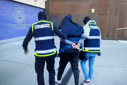 Dos agentes de la Policía Nacional trasladan a uno de los 14 detenidos en noviembre que fueron expulsados a Pakistán poco después, en una imagen facilitada entonces por Interior.