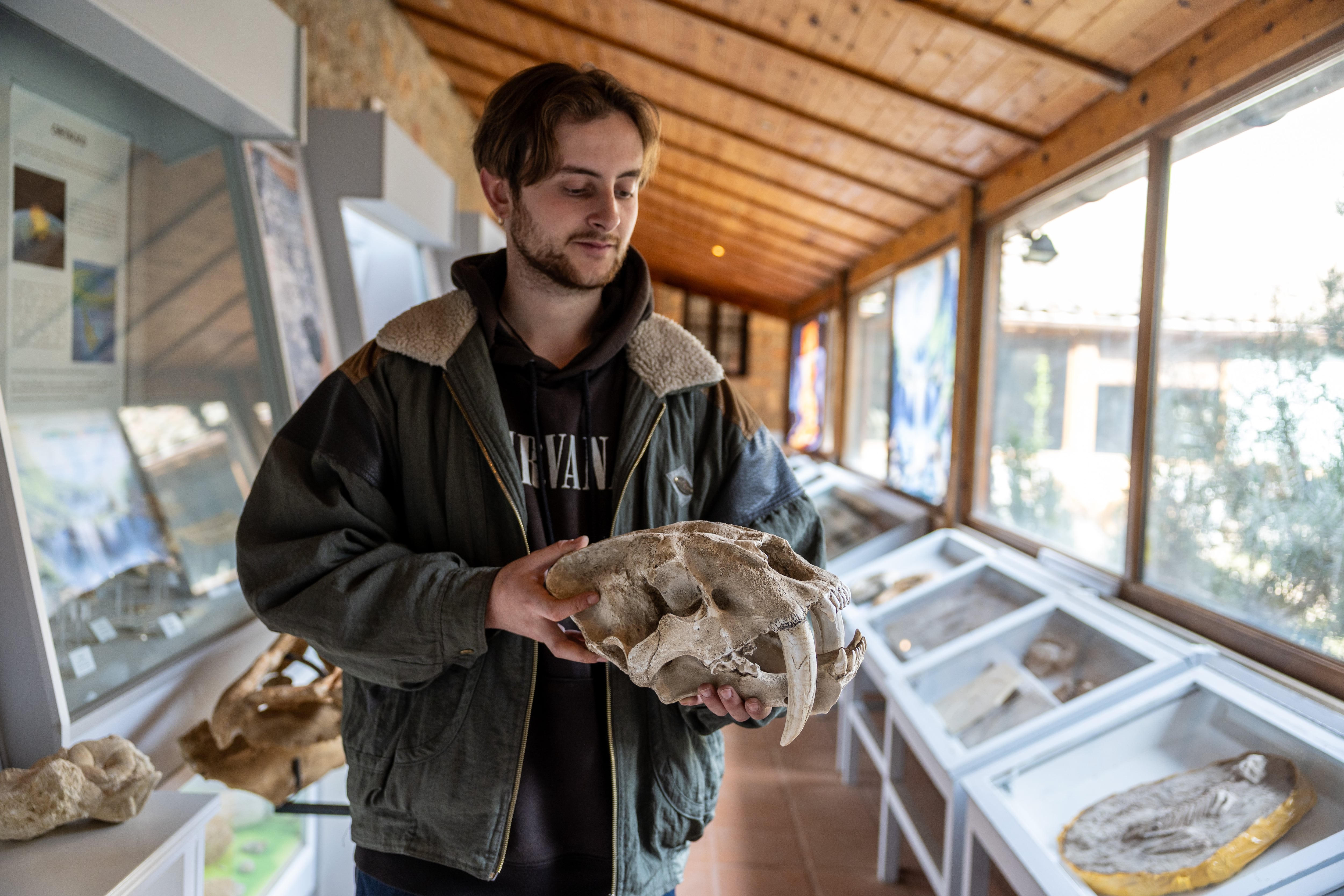 Hugo Hermosilla, arqueólogo de 22 años y trabajador del museo de Molina de Aragón, sostiene unos huesos de dinosaurio.