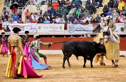 El banderillero Rafael González trata de sacar del caballo al cuarto toro de Baltasar Ibán.