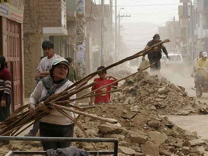 La familia Nolasco desescombra su vivienda destruida por el terremoto en la localidad peruana de Imperial.