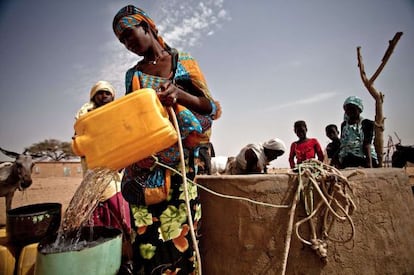Una mujer rellena un cubo de agua en Natriguel, en el sur de Mauritania.
