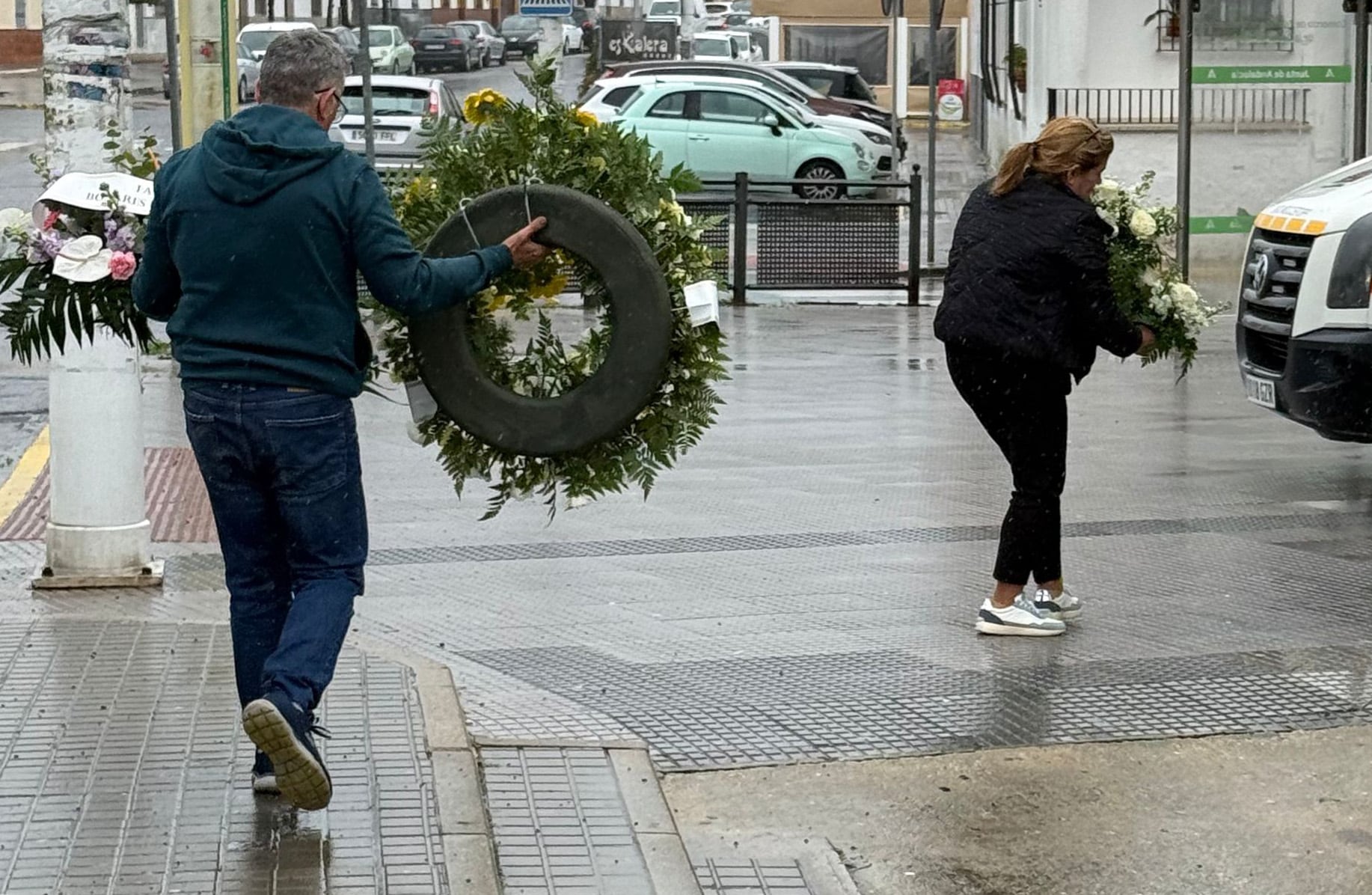 Llegan algunas personas con flores, este miércoles, al polideportivo municipal donde se instalará la capilla ardiente, en Aljaraque (Huelva).