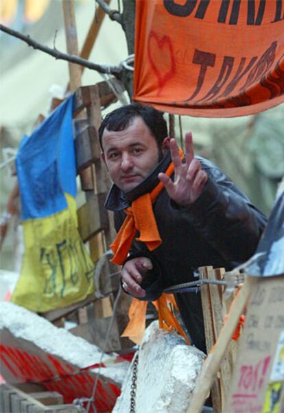 Un partidario de Yúshenko hace el signo de la victoria en el campamento que tienen instalado en Kiev.