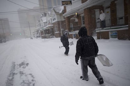 Dois homens com pás de neve em uma rua de Atlantic City. O ciclone de inverno prolonga uma sequência de dias de frio extremo que começou no dia do Natal na Costa Leste.