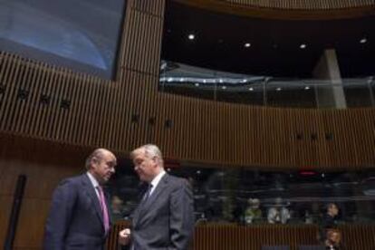 El ministro español de Economía y Competitividad, Luis de Guindos (i), conversa con el comisario europeo de Asuntos Económicos y Monetarios, Olli Rehn, antes del comienzo de la reunión de los ministros de Economía de la UE celebrada hoy en Luxemburgo.