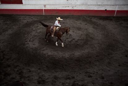 Un charro prepara a su caballo minutos antes de participar en una competición, La charreada reúne a concursantes de 27 de los 31 estados mexicanos. Para los participantes, el deporte es una pasión. Muchos tienen otros trabajos y dedican su tiempo libre a mejorar sus habilidades en las distintas disciplinas de la tradición.