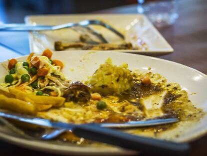 Un plato con comida sobrante tras un almuerzo en un restaurante.