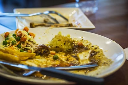 Un plato con comida sobrante tras un almuerzo en un restaurante.