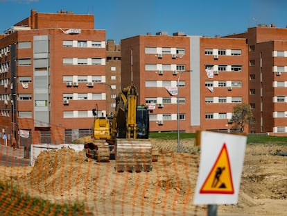 Una retroexcavadora en la parcela donde se construirá el cantón auxiliar de Vicálvaro. Al fondo, los vecinos han colgado carteles y lonas con mensajes contra la obra.