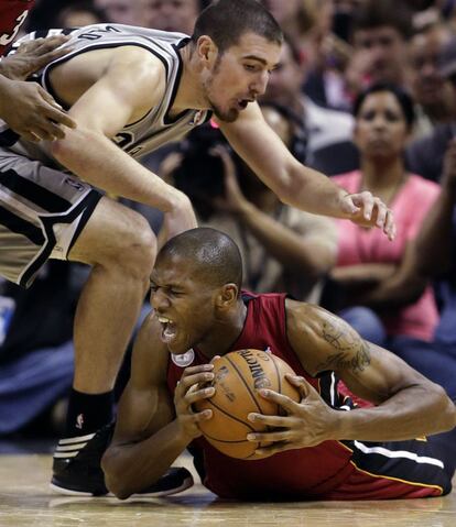 Jones, de los Heat, lucha por mantener el balón frente a De Colo, de los Spurs.