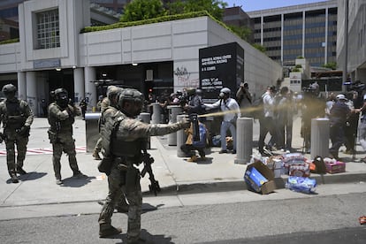 Guardias nacionales rocían gas pimienta a los manifestantes frente al centro de detención metropolitano, este domingo en Los Ángeles.