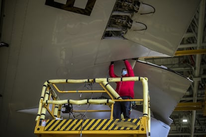 Un trabajador de Iberia comprueba los mecanismos de una de alas del Buenos Aires en los talleres de La Muñoza.