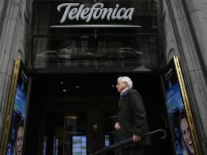 Un hombre pasea junto a la entrada de la sede de Telef&oacute;nica en Gran V&iacute;a.