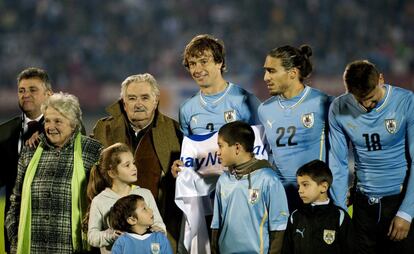 El presidente uruguayo José Mujica y su esposa Lucia Topolansky, junto a los futbolistas uruguayos Diego Lugano, Martín Cáceres y Néstor Ramírez (de izquierda a derecha), antes del inicio del partido de fútbol amistoso contra Eslovenia en el Estadio Centenario Montevideo, el 4 de junio de 2014.
