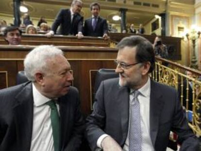 El presidente del Gobierno, Mariano Rajoy (d), conversa con el ministro de Educación, Cultura y Deporte, José Ignacio Wert, poco antes de su intervención en su primer debate sobre el estado de la nación al frente del Ejecutivo.