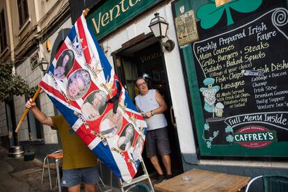 Un hombre sostiene una bandera con imágenes de la reina Isabel II, en una calle de Gibraltar, este viernes.