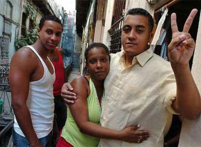 El opositor cubano Lázaro Alonso Román posa abrazado a su esposa y junto a su cuñado ayer en La Habana.