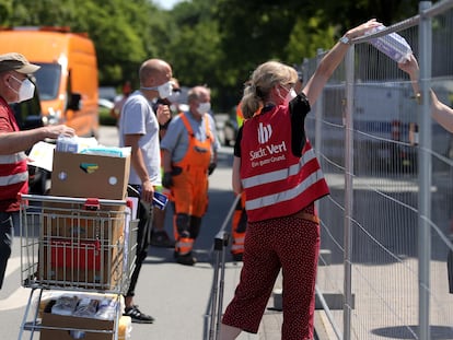 Una empleada municipal distribuye bienes de primera necesidad a las personas en cuarentena, en Verl, cerca del matadero de Gütersloh, al oeste de Alemania.