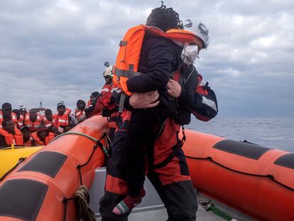 Un miembro del equipo del 'Sea-Watch 3' ayuda a abordar a un niño durante una operación de rescate en el Mediterráneo el 26 de febrero.