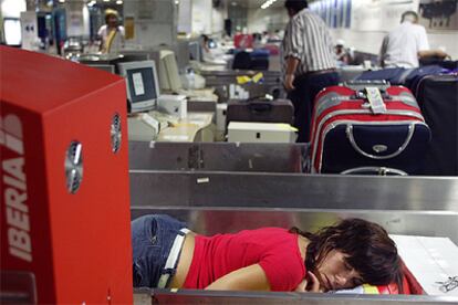 Una joven duerme en una cinta transportadora de equipajes.