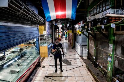 Un trabajador desinfecta el mercado central en San José, Costa Rica.