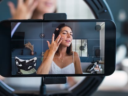 Una joven 'influencer' graba con su móvil mientras se maquilla.