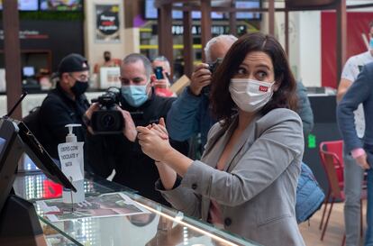 La presidenta de la Comunidad de Madrid, Isabel Díaz Ayuso, se lava las manos durante la presentación de la nueva zona de restauración del centro comercial  Intu Xanadú, en Arroyomolinos, Madrid (España).