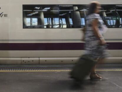 Varios viajeros esta ma&ntilde;ana en la estaci&oacute;n de Atocha delante de un AVE.