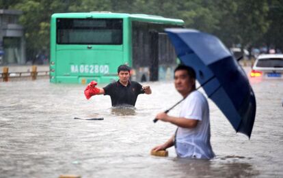 La situación de decenas de embalses y presas preocupa especialmente a las autoridades chinas. Además del riesgo de desbordamiento de muchos de ellos, hay dos presas cuyos muros se han agrietado. En Luoyang, una localidad de siete millones de habitantes al oeste de Zhengzhou, el embalse de Yihetan presenta una grieta de 20 metros en su muro de contención, según confirmó el ejército chino en un comunicado, que alertó de que la presa “puede colapsar en cualquier momento”. En la imagen, dos personas en una calle de Zhengzhou.