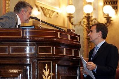 Rodríguez Zapatero charla con el presidente del Congreso, Manuel Marín, esta tarde al subir a la tribuna.