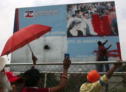 Un trabajador pinta sobre la cara Manuel Rosales, alcalde de Maracaibo y opositor a Chávez, en el puerto de la cuidad, tras la toma del control de las instalaciones por parte del Ejército.