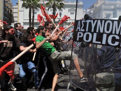 Manifestantes armados con palos y policías chocan en los enfrentamientos registrados ayer en Atenas, durante el Primero de Mayo, ante la sede del Parlamento griego.