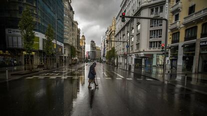 Una mujer cruza la Gran Vía de Madrid, desierta por el confinamiento, el 23 de marzo de 2020.