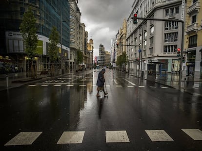 Una mujer cruza la Gran Vía de Madrid, desierta por el confinamiento, el 23 de marzo de 2020.