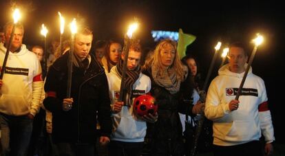 Participantes de la marcha portan antorchas.