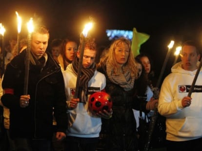 Participantes de la marcha portan antorchas.