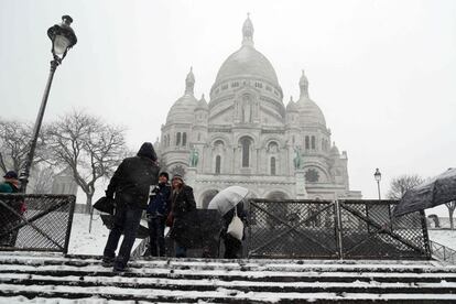 Un grupo de turistas suben las escaleras que conducen a la basílica del Sagrado Corazón de París.