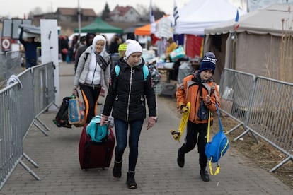 Una familia de refugiados ucranios cruza el campamento de Medyka (Polonia).