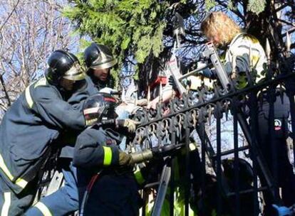 Los bomberos y médicos de Emergencias, durante el rescate en el Retiro.