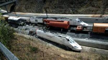 Un tren pasa junto a los restos del ferrocarril que el pasado 24 de julio descarriló en las inmediaciones de Santiago de Compostela. EFE/Archivo